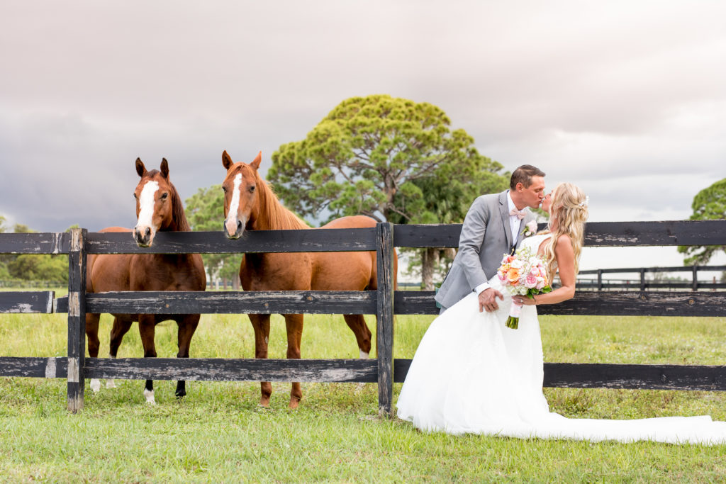 Ever After Farms Ranch - Photo Credit Kelilina Photography - couple kissing in front of fence and two horses